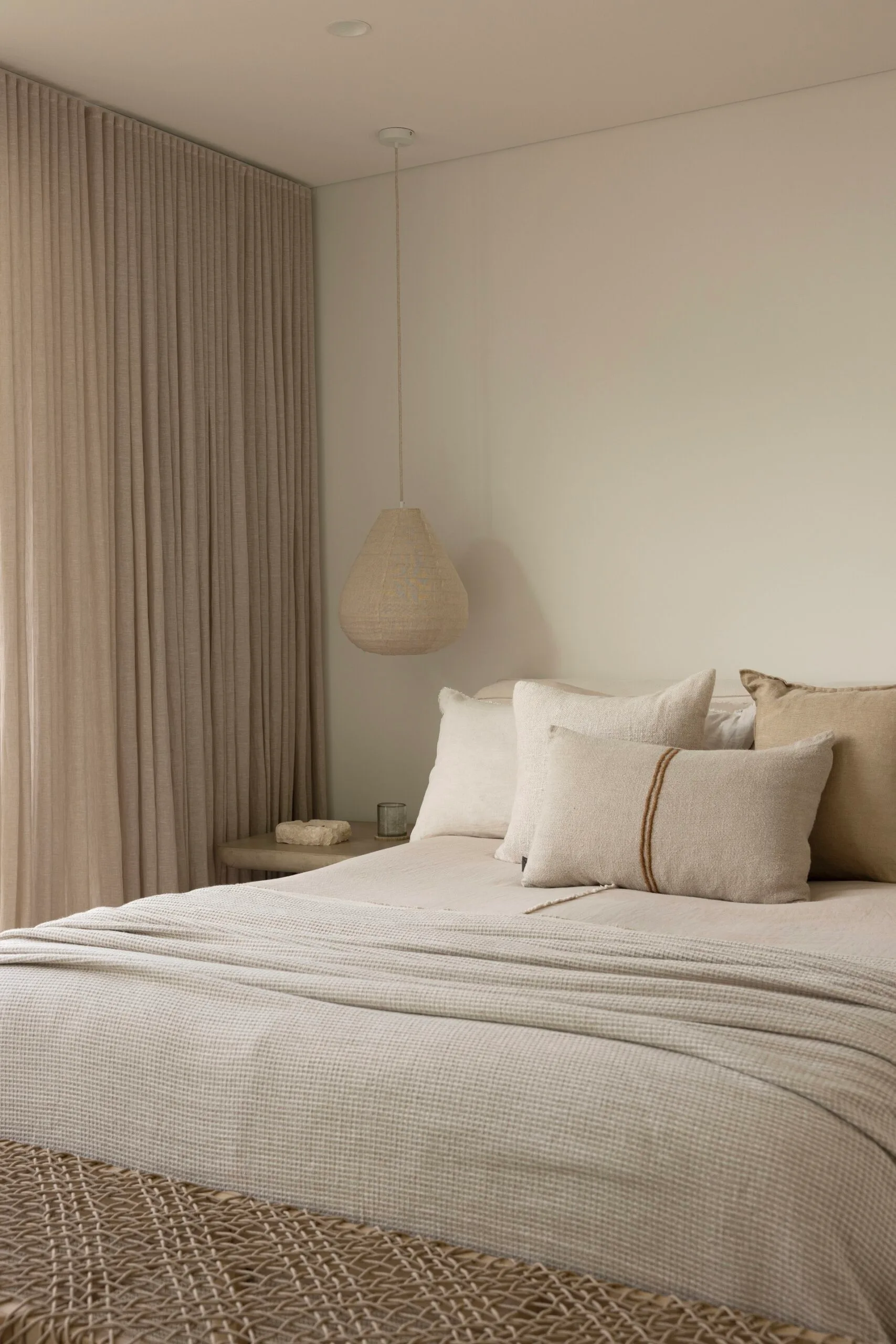 Bedroom in a coastal Sydney house with a neutral, beige Mediterranean aesthetic.