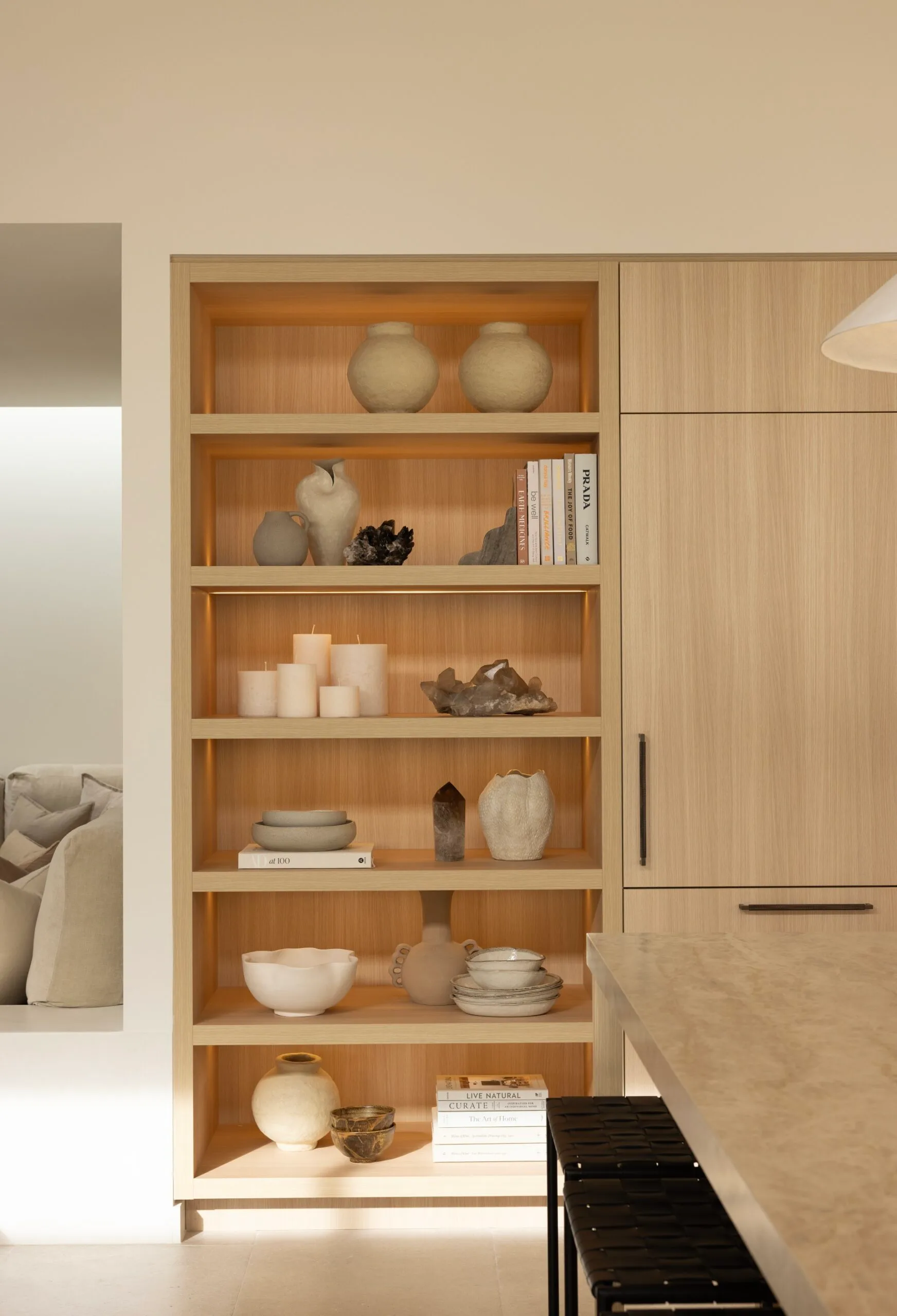Styled timber bookshelves in a coastal Sydney house with a neutral, beige Mediterranean aesthetic.