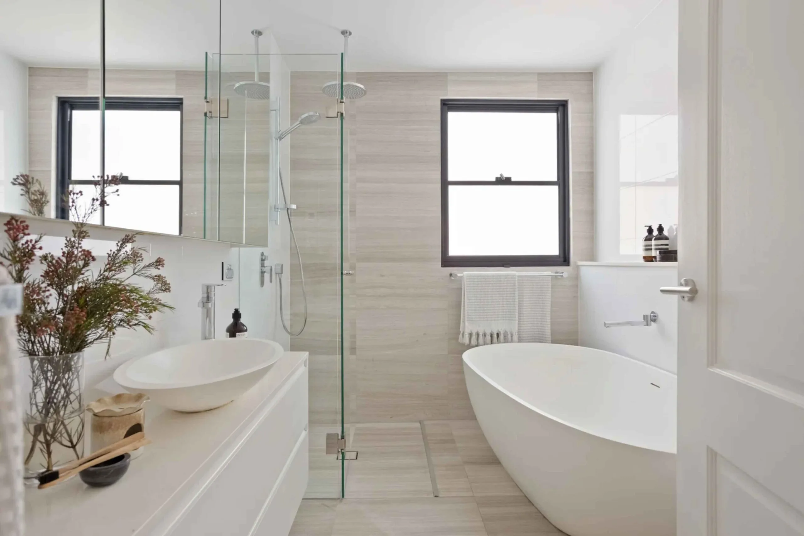 Contemporary bathroom featuring biege tiles and a freestanding bathtub in a Sydney house.