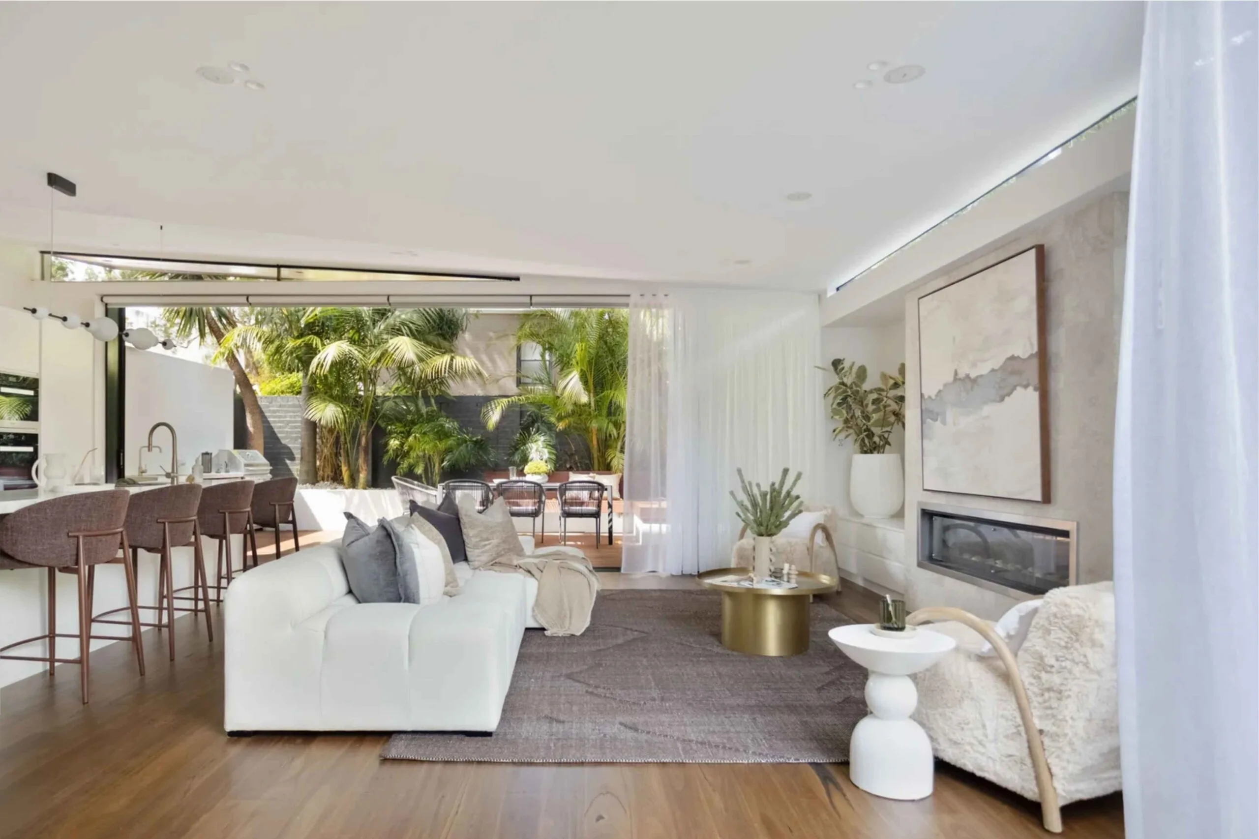 Family room or casual living room in the extension of a Victorian-era house in Sydney, with white furniture and a mauve rug.