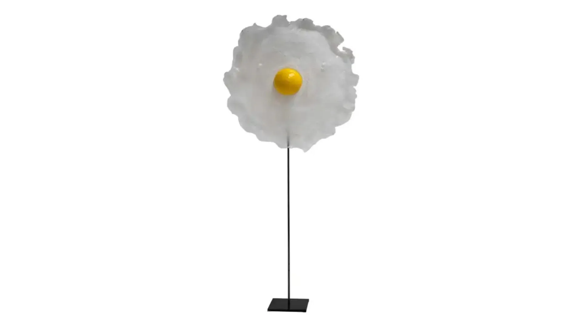 Table lamp on a thin stand with a small yellow sphere on a wide, flat round white surface. The design is reminiscent of a cracked egg.