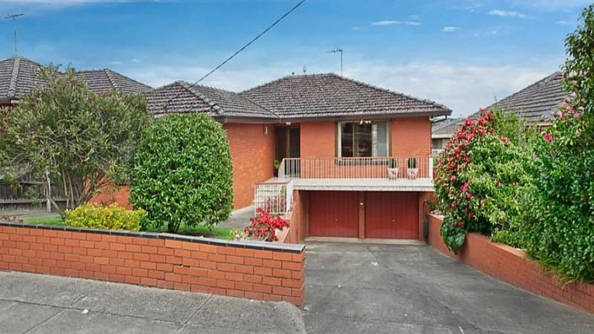 The original red brick exterior with two car garage and hedges for my reno rules