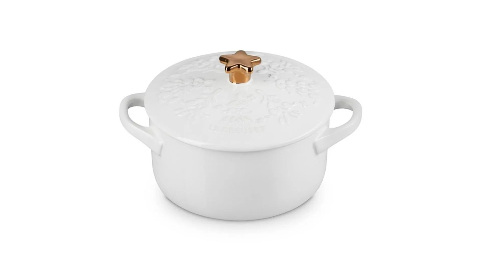 A white small casserole dish with a lid that has a Christmas tree pattern on it and a gold knob in the shape of a star.