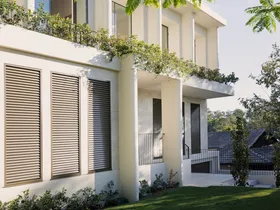 Modern two-story house with large windows, surrounded by greenery and trees, under a clear blue sky.