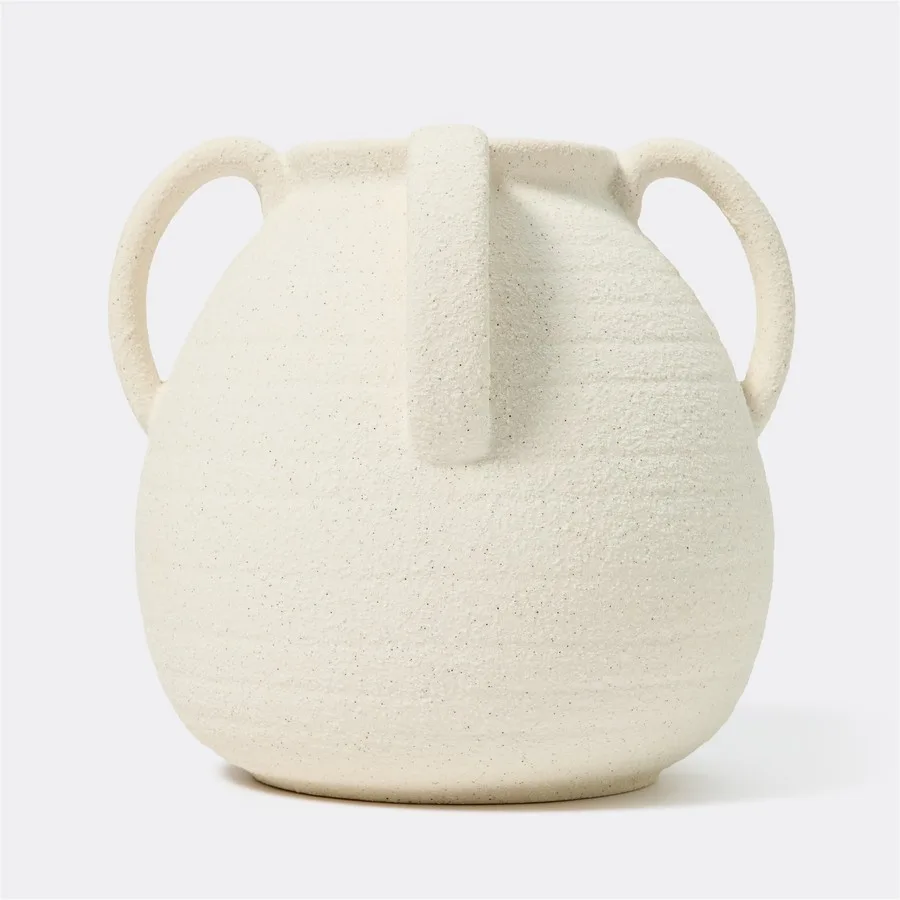 The off-white Openook Nora Handle Vase features a satisfyingly rough, granular texture and four small handles. Its timeless shape and rustic feel make it the perfect anchor for dried pampas or a stylish standalone piece.