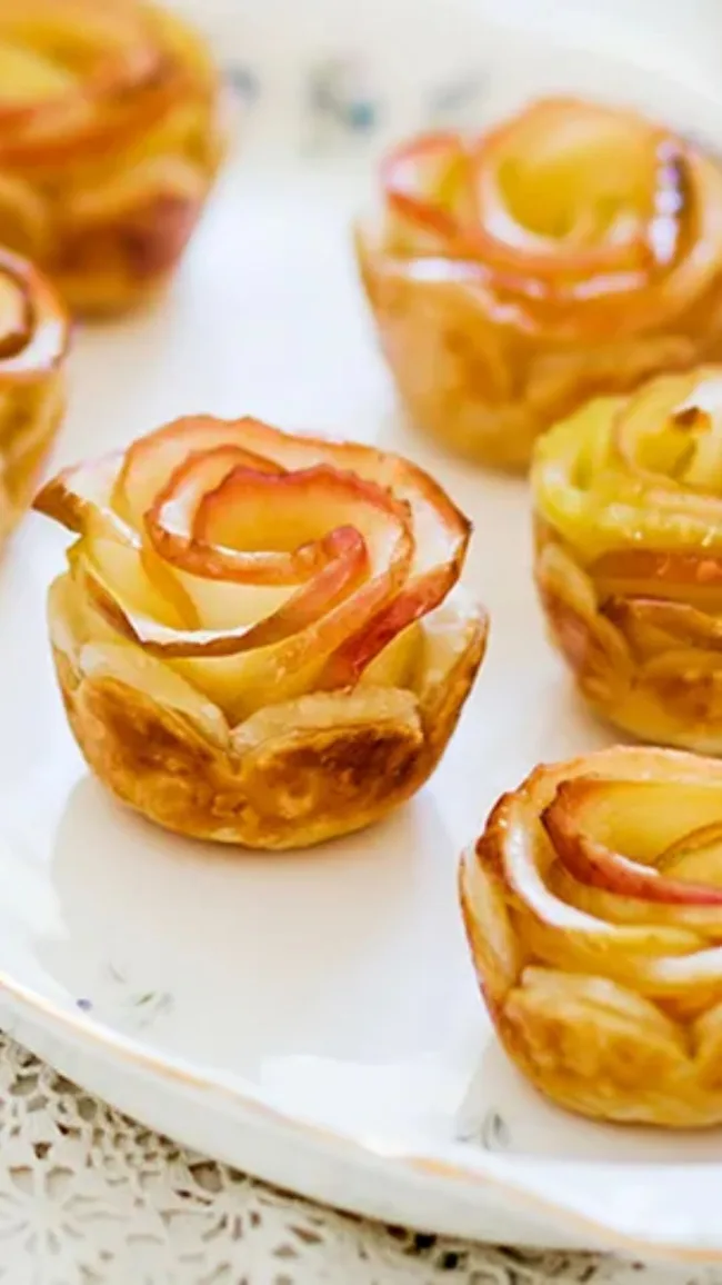 mini Apple rosebud tarts displayed on a white plate