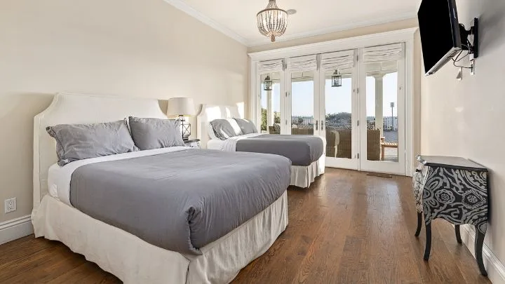 two double grey beds in a large bedroom in the hannah montana house