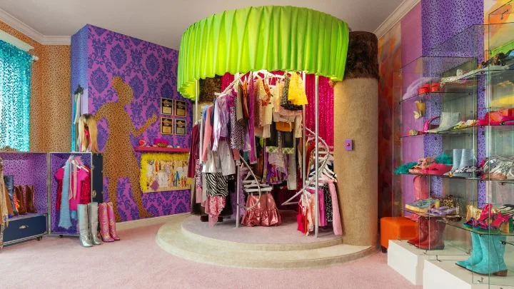 a recreated closet from Hannah Montana with a platform purple walls and acid green curtain