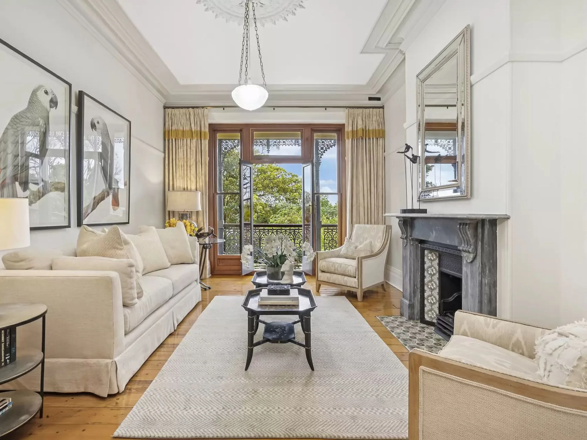 A creame living room with a fire place and balcony, inside Highroyd an historic Annandale Witches House 