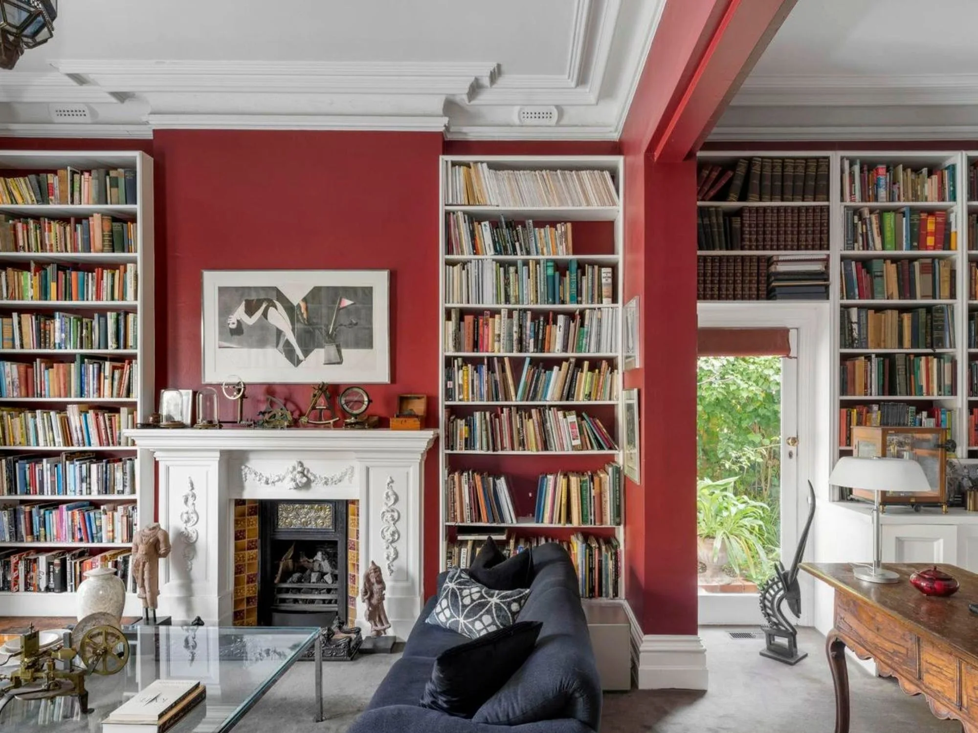 A red library and fireplace in Hilton House Hawthorne 