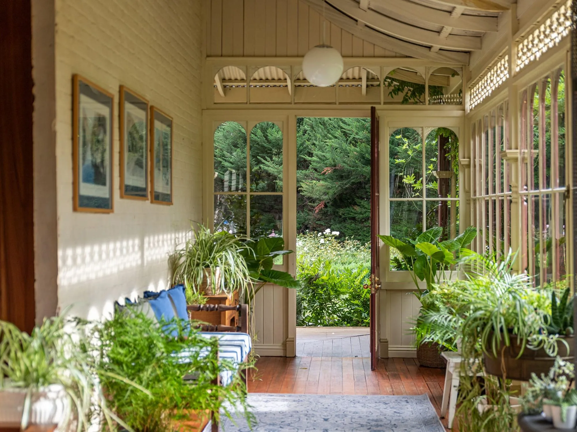 A hallway conservatory with lush green plants at Glen Derwent House tasmania 