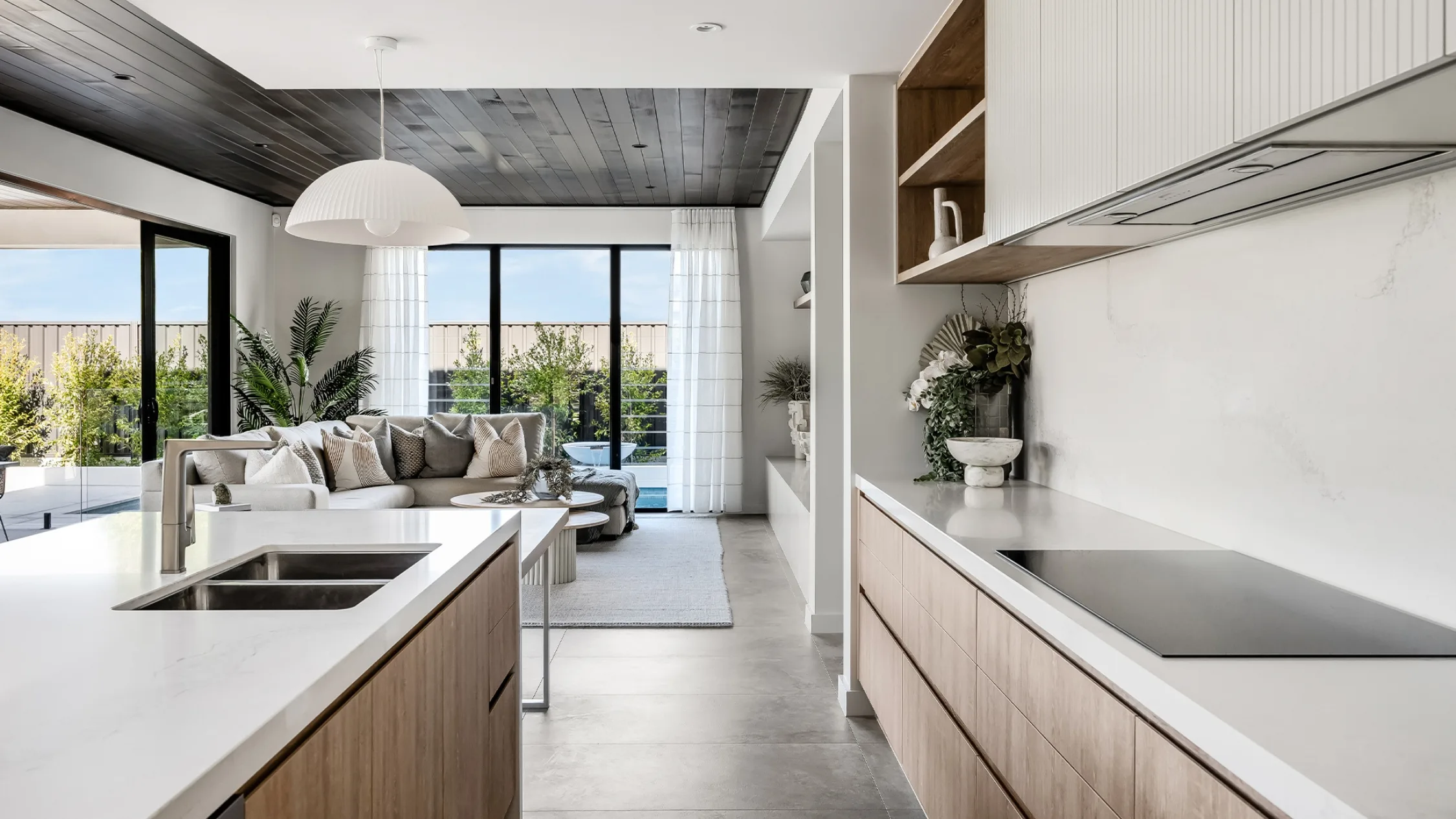 All white kitchen with timber cabinetry and black Japan timber lined ceiling