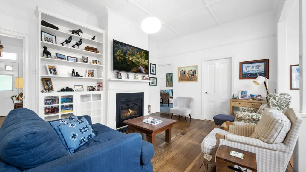 white living room with blue sofa and hardwood floors in Neale Whitaker's new Berry home