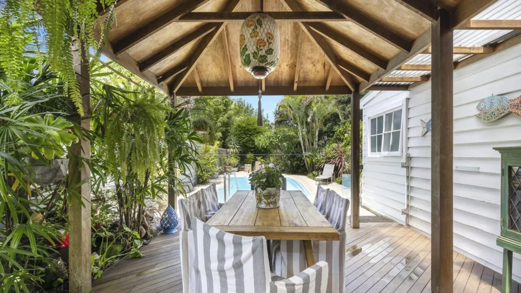 The outdoor dining area with timber pitched ceiling overlooking a pool at Neale Whitaker's new home
