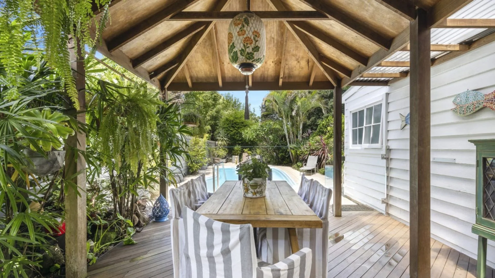The outdoor dining area with timber pitched ceiling overlooking a pool at Neale Whitaker's new home