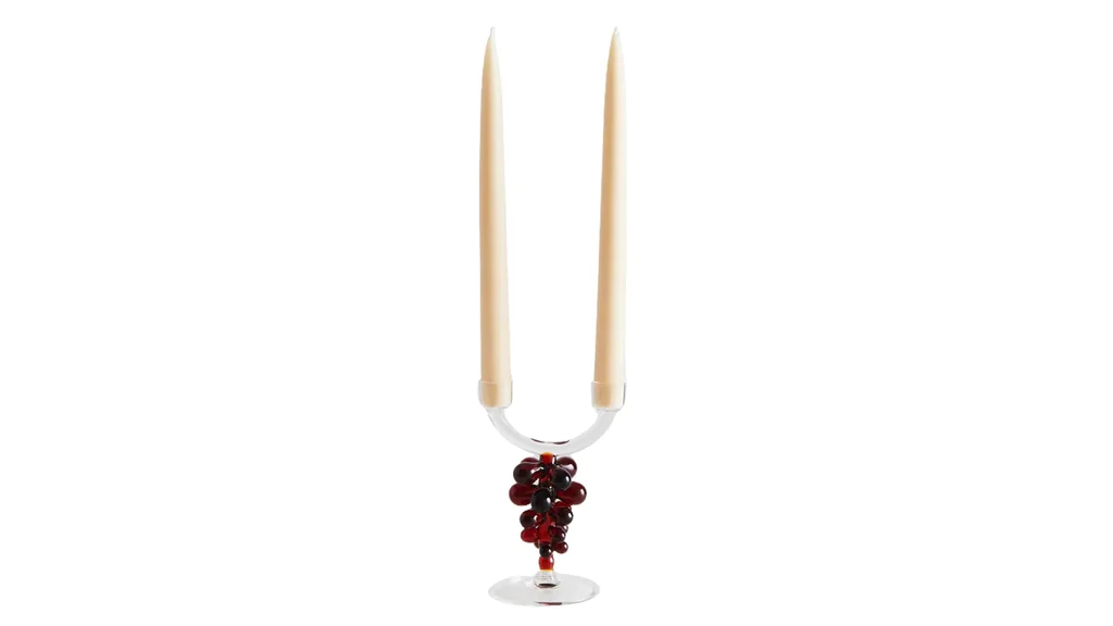 A glass candlestick holder, that fits two candlesticks, with a berry design on the handle, perfect for dark cottagecore styles.
