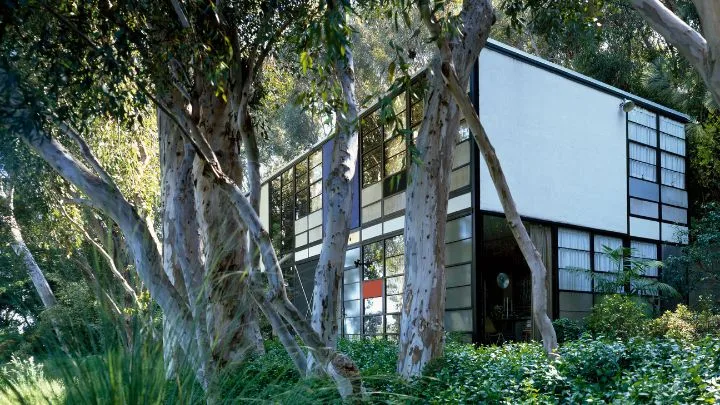 The exterior of Eames house with its many rectangular window tiles with some filled in with primary colours