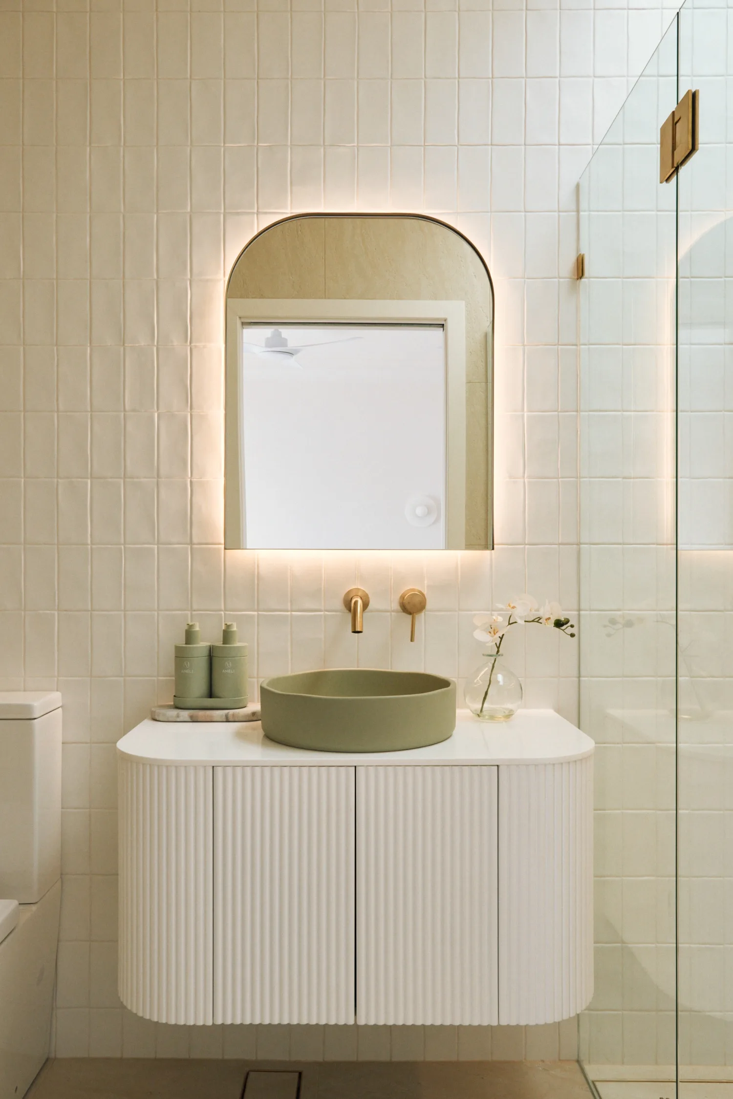 White kitchen with sage green round basin and fold tap details
