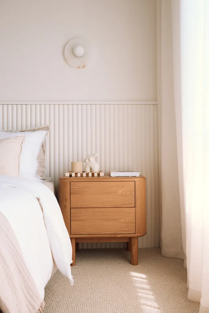 White new bedroom with textured wall and timber bedside table
