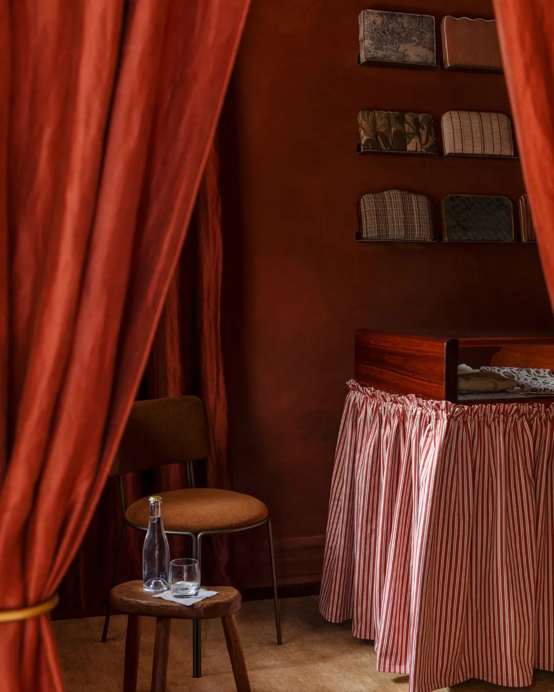 A red room with a red curtained counter through heavy red fabric curtains at the Bedhead Bar in Perth