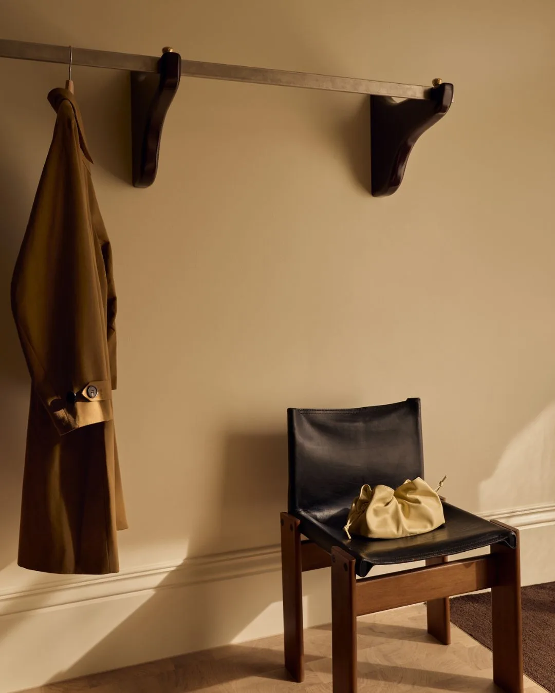 A black leather arm chair and an antique timber coat rail in the Friends With Frank Armadale retail store