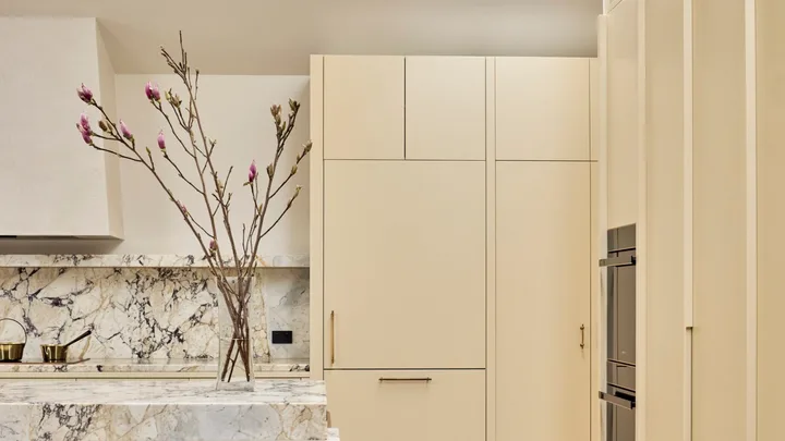 Contemporary kitchen with warm neutrals and earth tones, marble splashback, herringbone floors and a skylight.