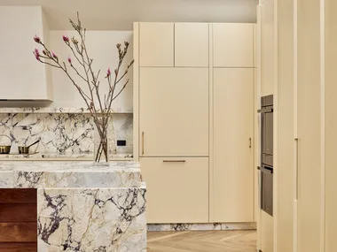 Contemporary kitchen with warm neutrals and earth tones, marble splashback, herringbone floors and a skylight.