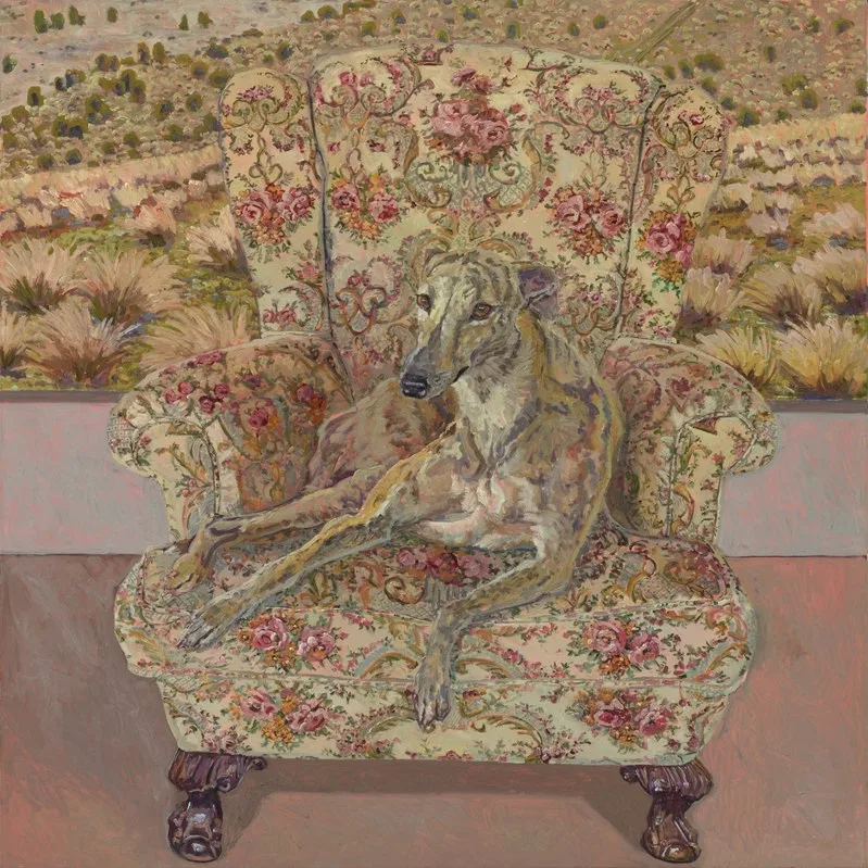 Oil on canvas painting of a dog sitting on a floral patterned wingback armchair, in front of a landscape painting.