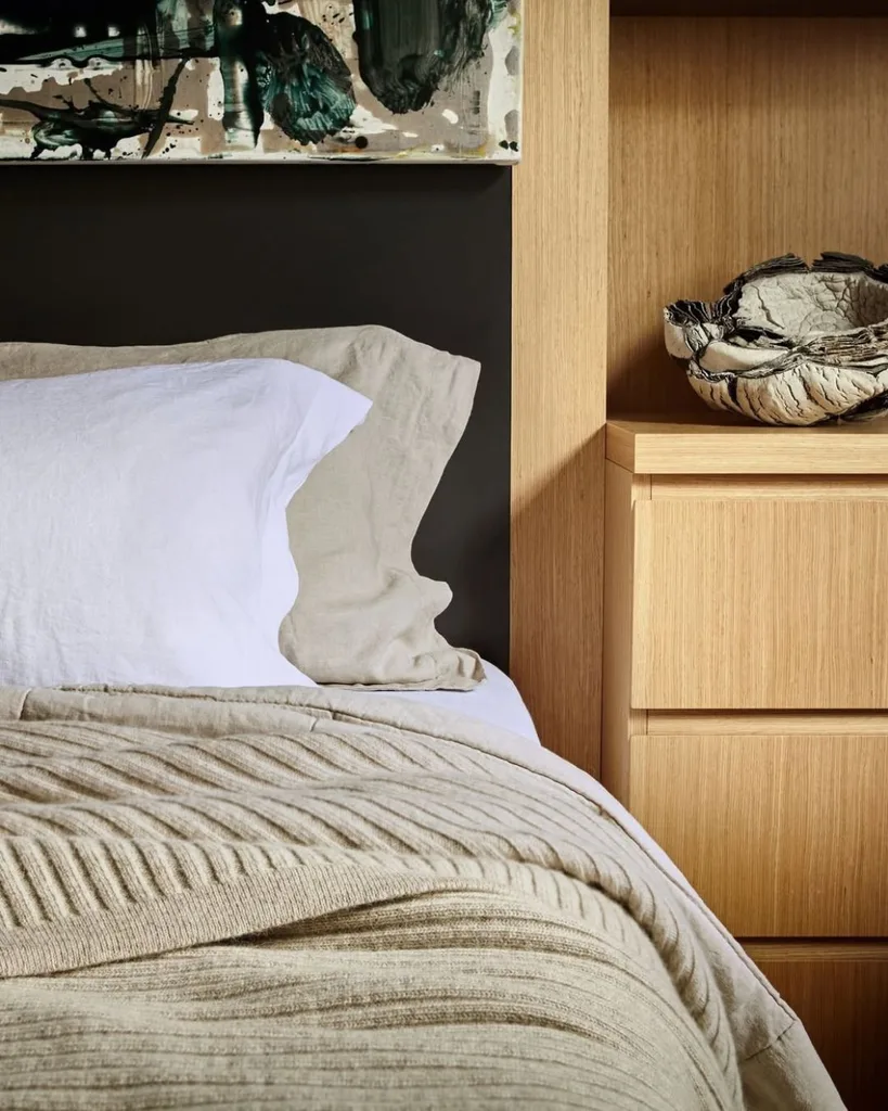A warm beige bed covered with a ribbed wool blanket