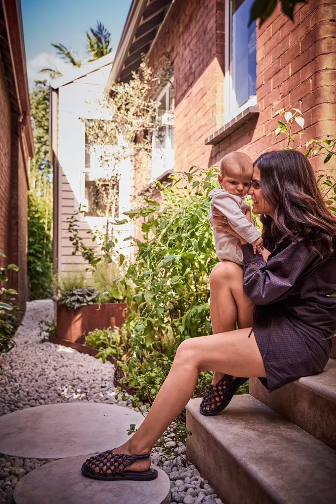 Steph holding her daughter Ilaria in the courtyard
