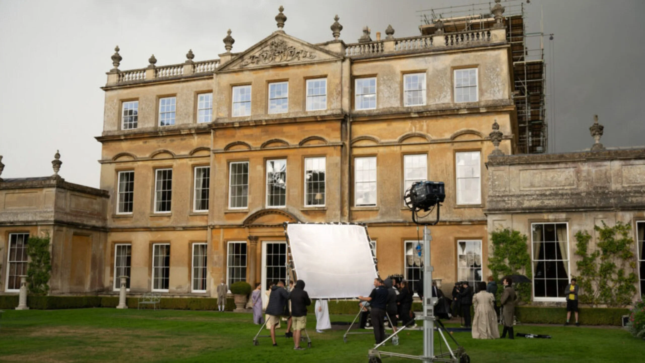 The exterior of a grand Georgian estate, with a film crew out the front.