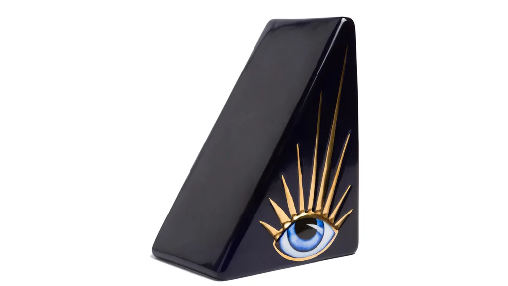 Triangular black bookend with a blue eye and gold lashes painted on