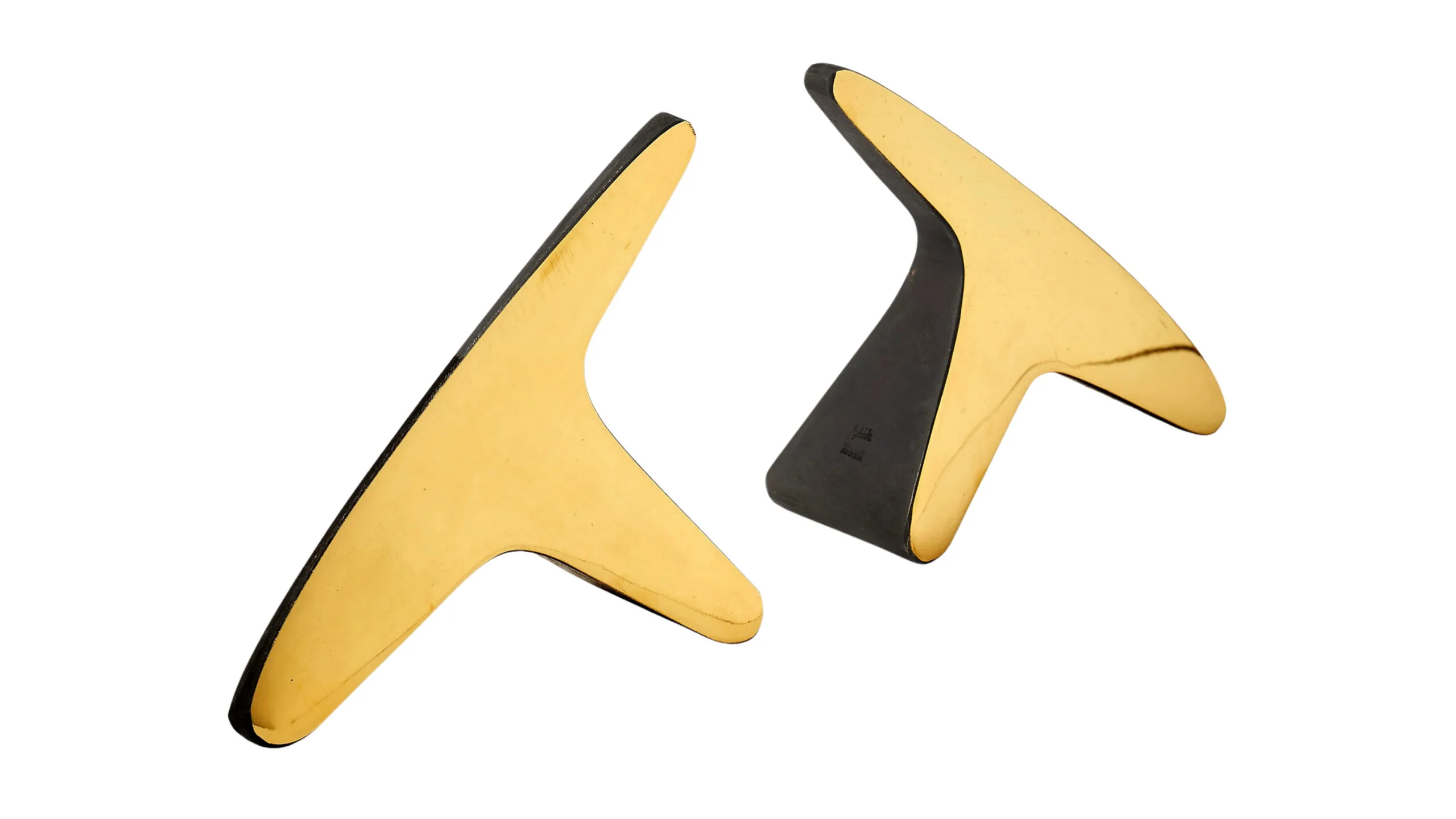 Two gold bookends in 'T' shapes.