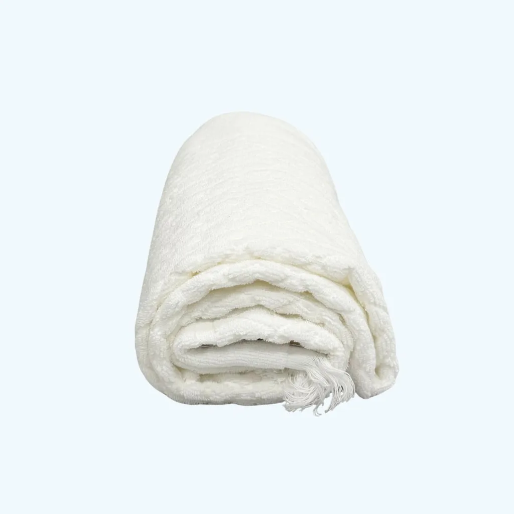 a white bath towel neatly rolled like a spa twoel