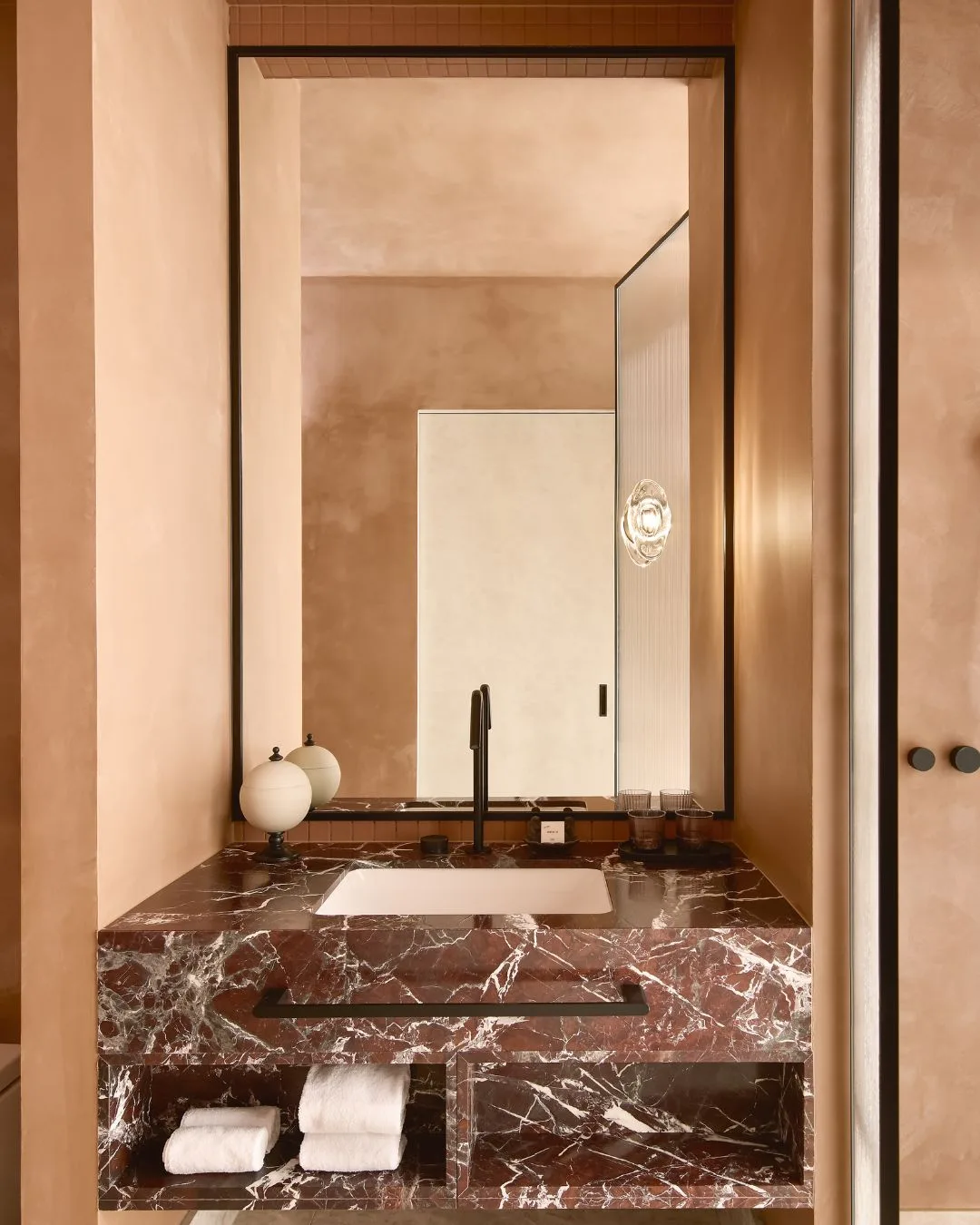 a bathroom counter with maroon marble vanity at the Mondrian Gold Coast