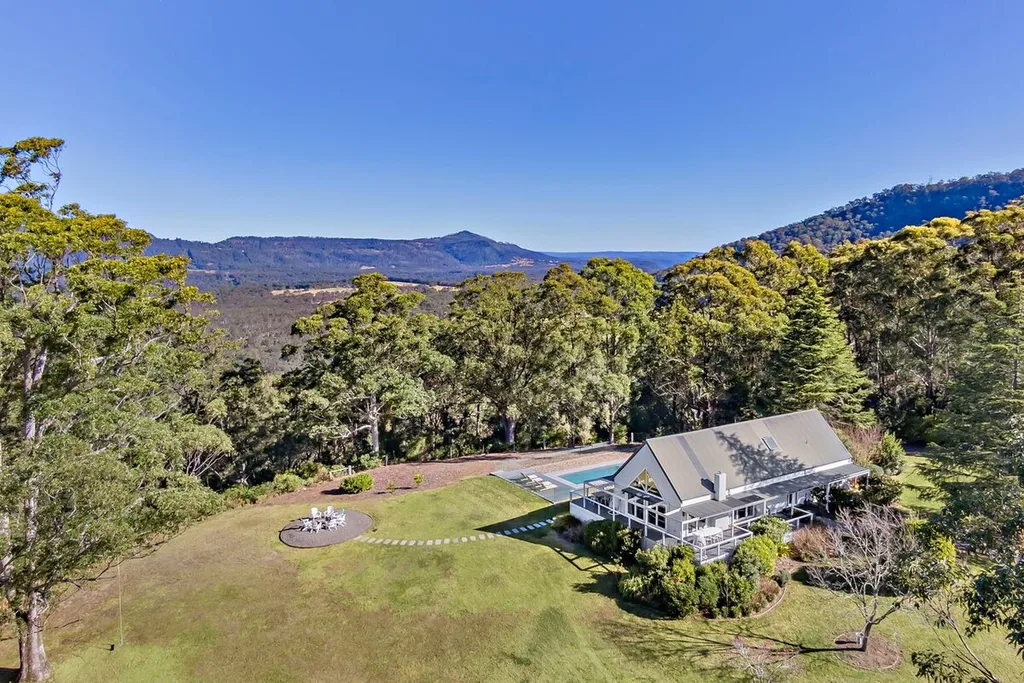 Kangaroo Valley accommodation backyard with white house exterior and large outdoor firepit area
