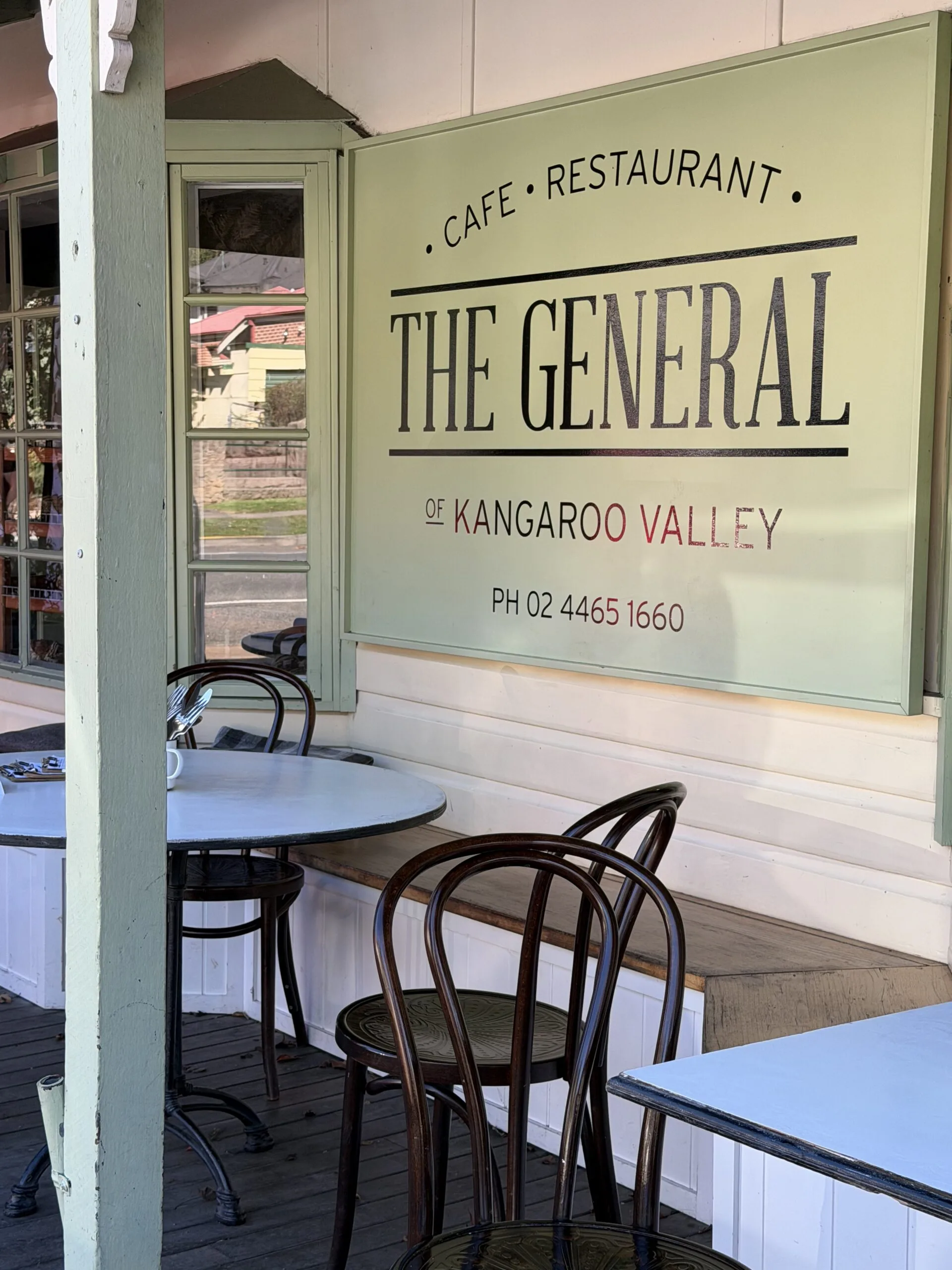 Outdoor seating at The General cafe in Kangaroo Valley, featuring round tables and decorative chairs.