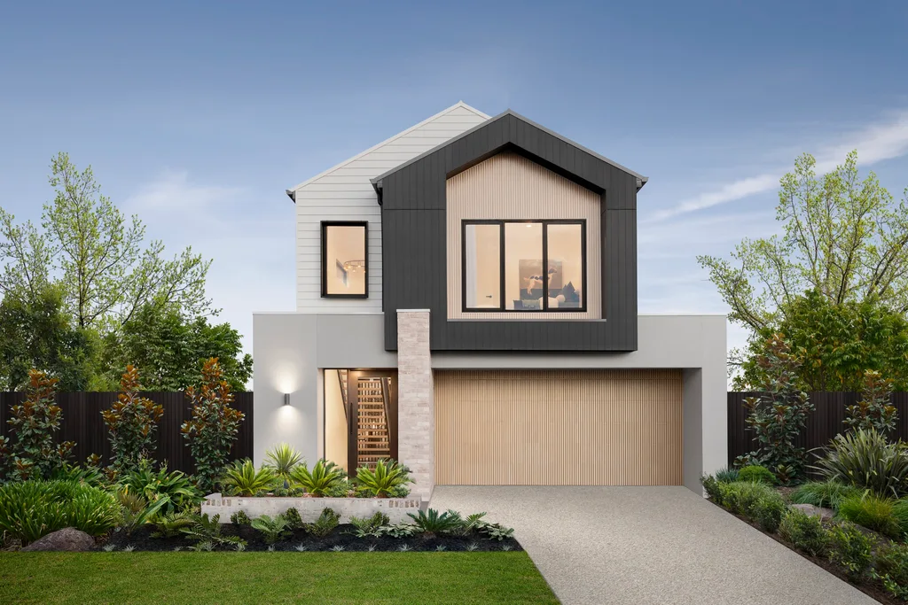 Modern two-story house with a black and white exterior, large windows, and surrounding greenery under a clear blue sky.