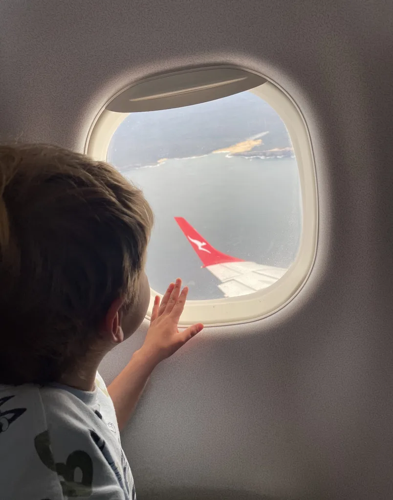Child looking out window on plane