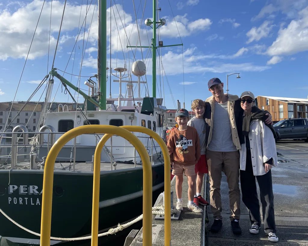 Family photo next to boat in Hobart