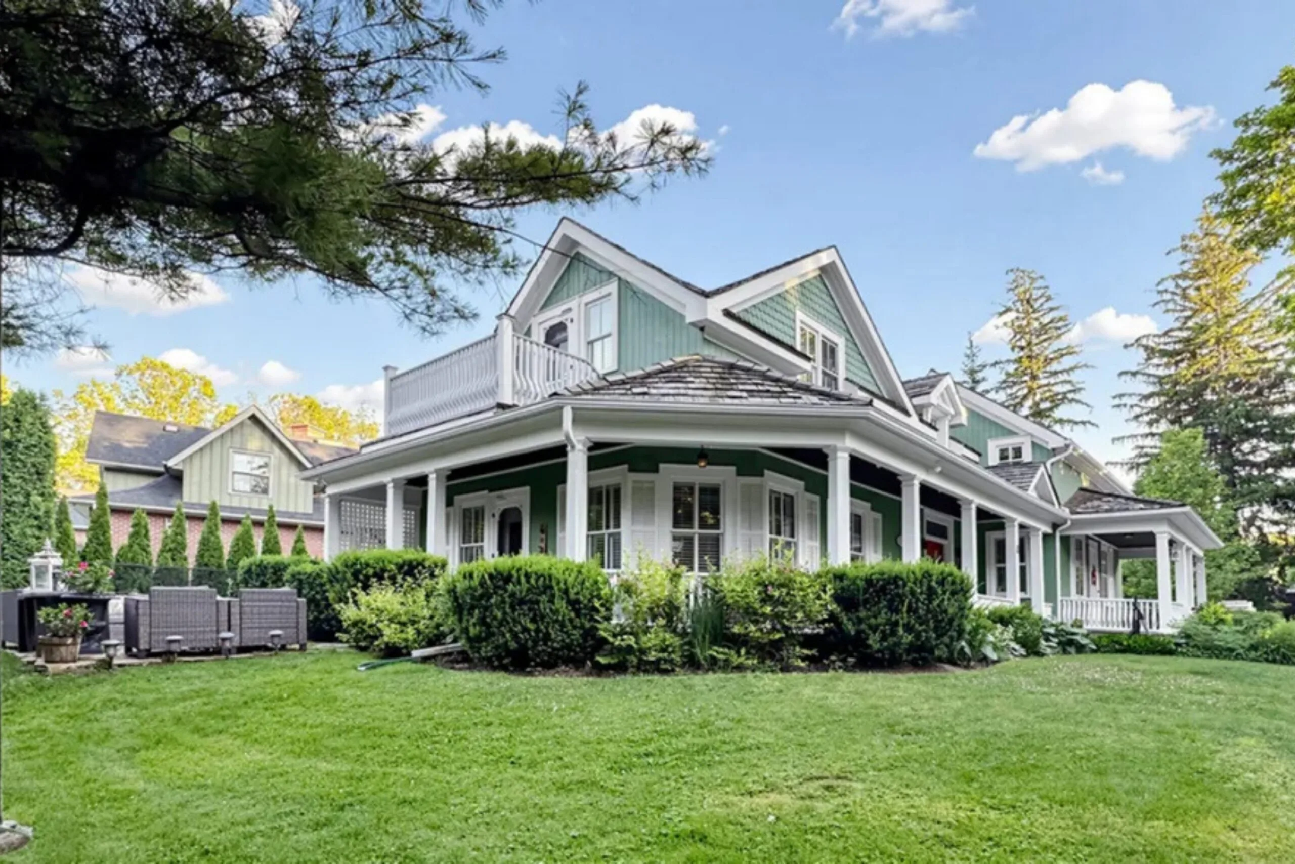 Rear exterior of the original Gilmore Girls house featuring a wraparound verandah, landscaped gardens and expansive lawn.