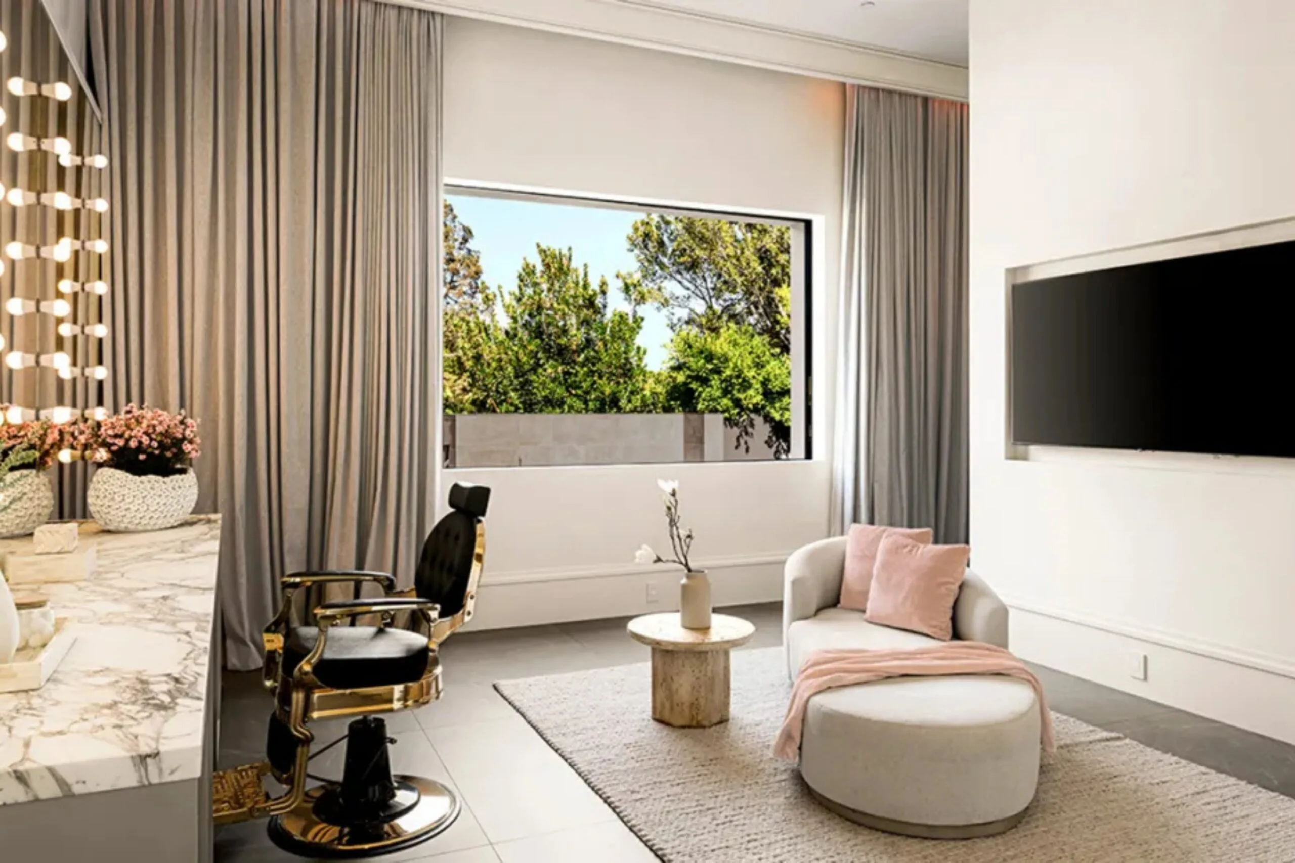 Beauty room inside Kylie Jenner&rsquo;s Los Angeles home with a marble vanity, salon chair and curved white sofa.