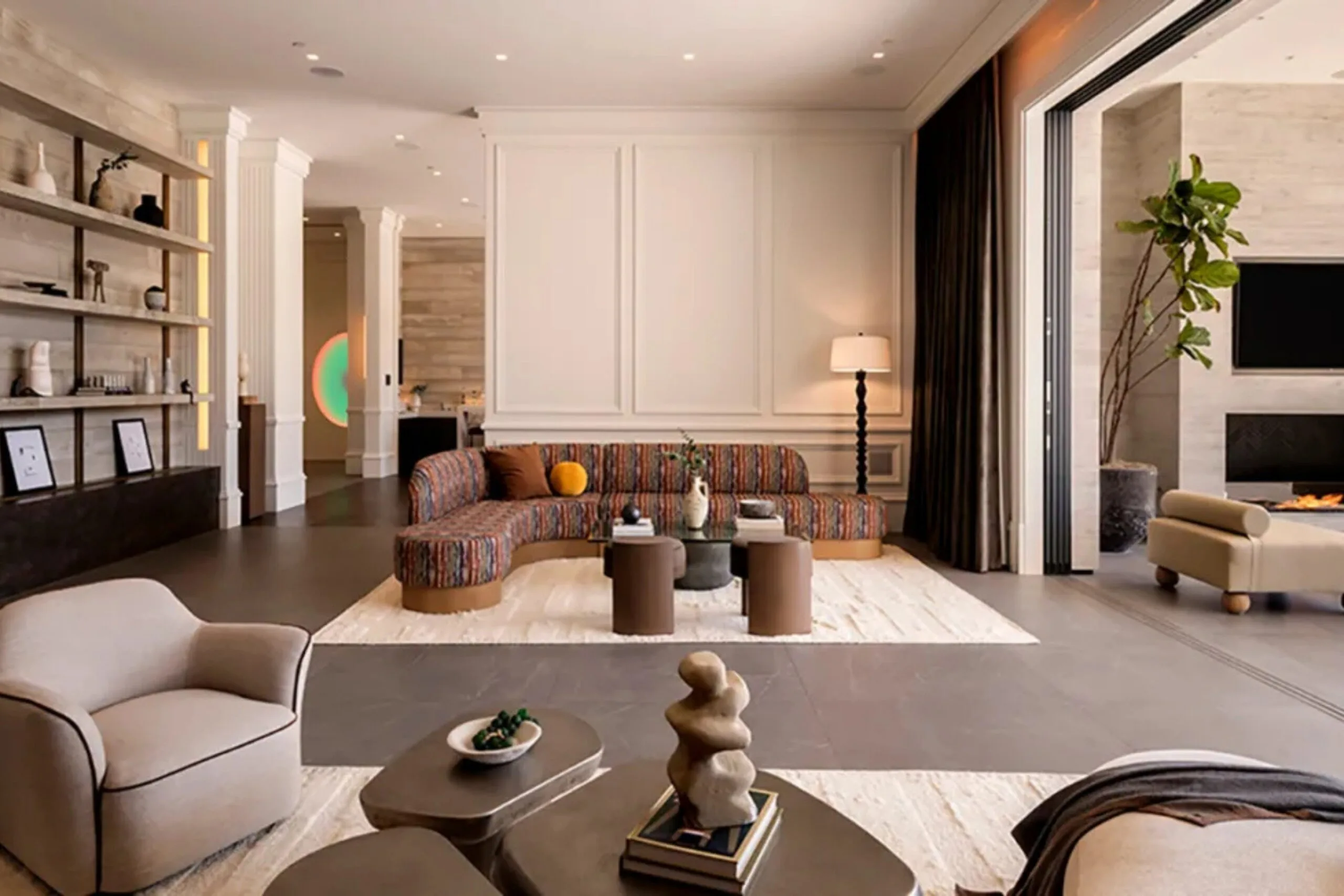Neutral formal living room inside Kylie Jenner&rsquo;s Holmby Hills mansion with sculptural furniture, colourful curved sofa and courtyard views.