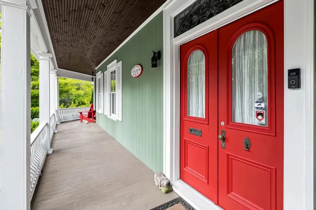 Wraparound Victorian verandah with a bright red front door and white trim at the original Gilmore Girls house.