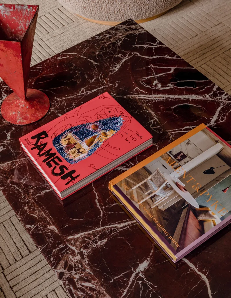 A burgundy rouge marble coffee table with pink coffee table book and vase