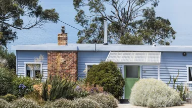 Blue weatherboard beachhouse exterior in front of ocean views