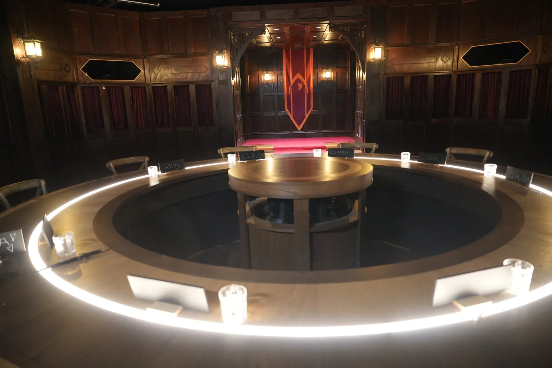The Round Table room inside Castle Claremont, featuring dark timber panelling, lantern lighting and the famous red carpet used in The Traitors Australia.