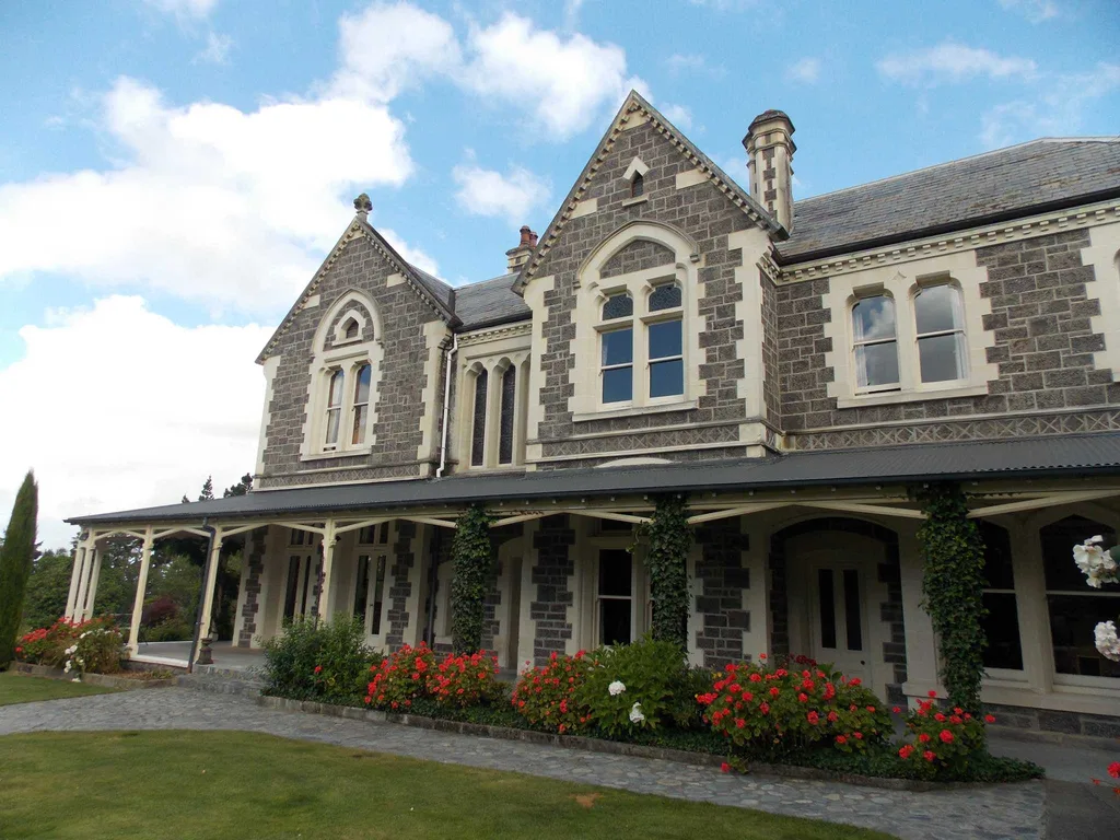 The Victorian Gothic façade of Castle Claremont, featuring bluestone walls, arched windows, wraparound verandah and landscaped gardens.
