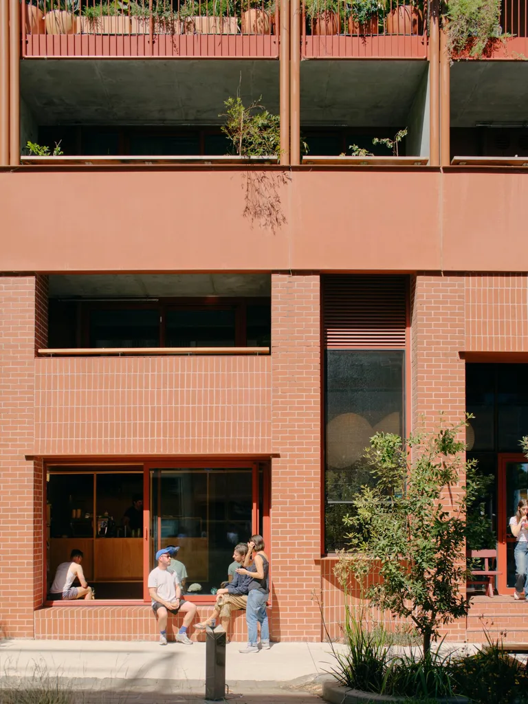 a brick cafe facade beneath an apartment building where community has gathered