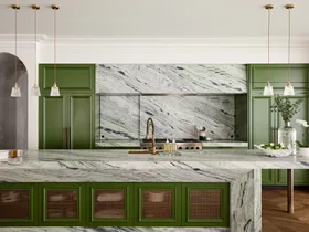 A large family kitchen that balances the latest kitchen trends with a sense of timelessness. Boldly veined stone covers the benchtops, splashbacks, rangehood cover and island surrounds. A deep green paint has been used on the joinery profiles, while brass pendants hang from the ceiling. Brass mesh squares are on the joinery profiles on the side of the kitchen island.